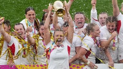 England's players celebrate as Zoe Aldcroft lifts the Women's Rugby World trophy