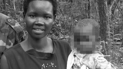 Evelyn Amony holding her daughter, standing beside two male relatives in the LRA, in the Democratic Republic of Congo in 2006