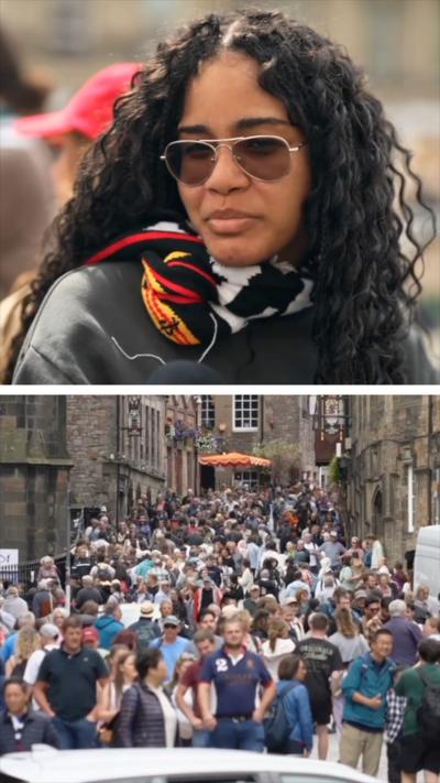Tourists on Edinburgh's Royal Mile, with the large brown buildings on either side of the cobbled streets