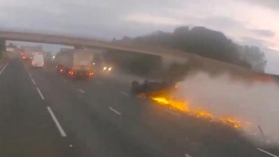 Car sliding along on its roof with sparks coming out of it after it was rammed from behind by a drink driver.