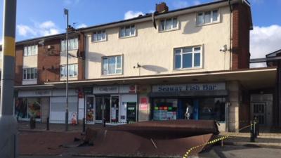 Roof debris cordoned off at shops