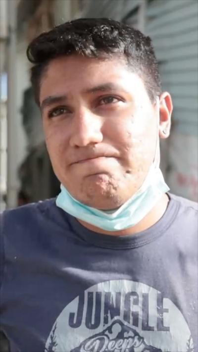 A young man with dark hair and a face mask