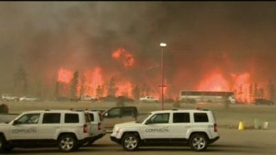 Vehicles driving past towering fires