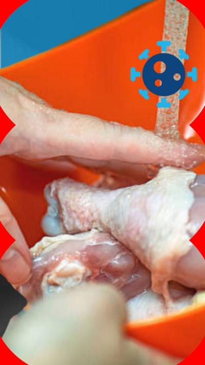 Hands washing chicken in a bowl