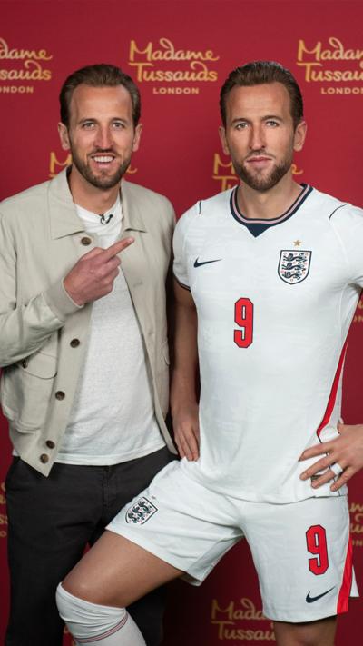 Harry Kane stands next to waxwork of himself.