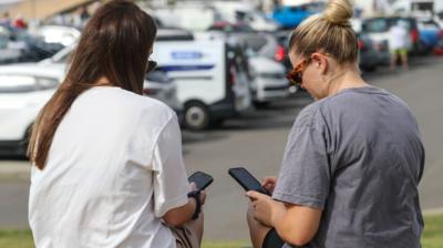 pobl ar eu ffonau symudol