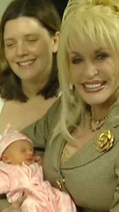 Dolly Parton with a baby in her arms and the infant's mother next to her in the UK in 2007
