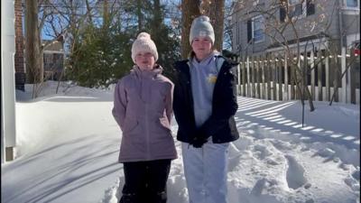 two girls standing in snow