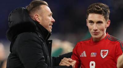 Craig Bellamy (L) celebrates with Harry Wilson