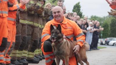 Frankie the retiring service dog with her handler Steven Carr, flanked by members of TWFRS