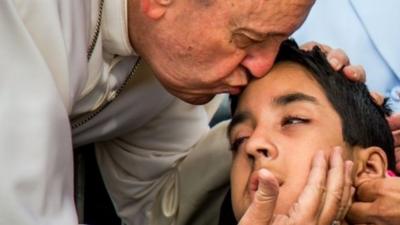 Pope Francis kissing child's head