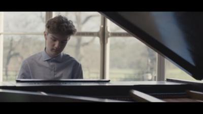 Harry Gardner sitting at a grand piano