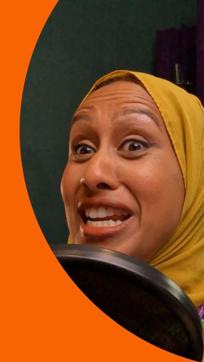 A woman speaking into a microphone with a surprised face