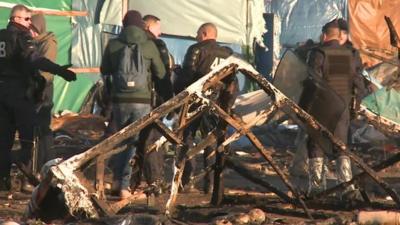 Police at Calais migrant camp