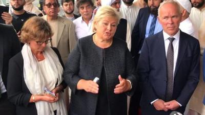 Erna Solberg talks to the press in this crowd photo