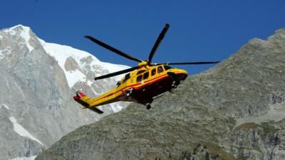 A helicopter rescues people stuck in cable cars in the French Alps