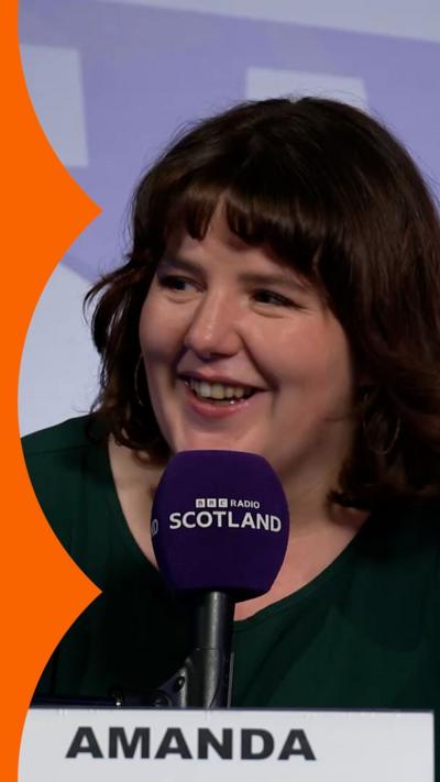 Amanda speaking into a BBC Radio Scotland microphone and smiling