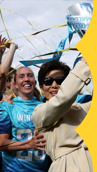Club owner Michele Kang holding up a trophy with players from London City Lionesses
