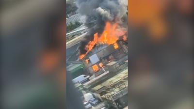 Flames and smoke emerged from a building in the middle of the picture