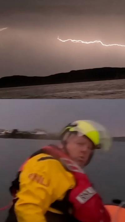 A lightning strike in the sky and a man in RNLI gear on the water