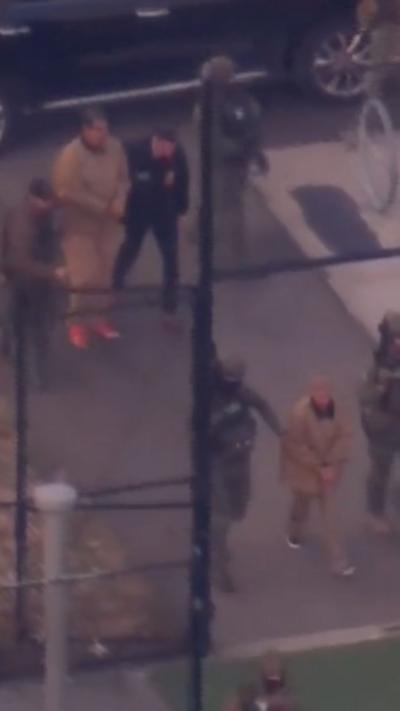 Maduro and wife, handcuffed, being taken to helicopter