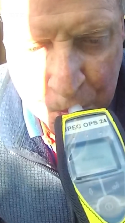A man using a breathalyser machine