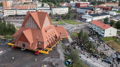 People watch as the Kiruna Church landmark is being moved