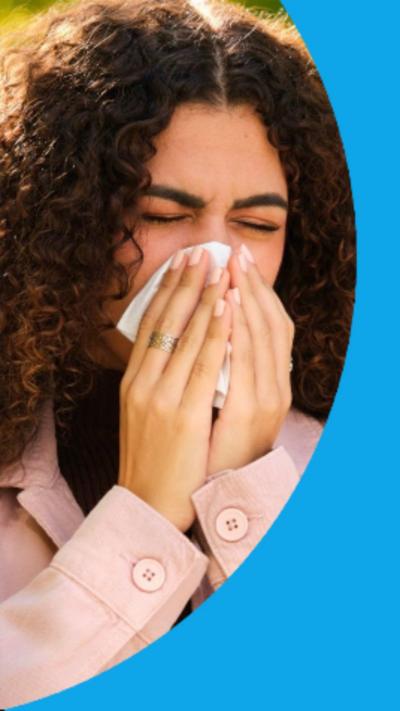 A woman in discomfort presses a tissue to her nose