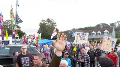 Demonstrators shouted and held placards in front of the camera