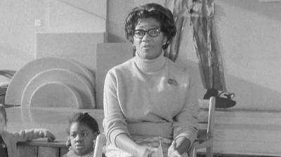 Black headteacher in classroom with Child