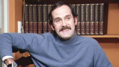 John Cleese wears a blue jumper