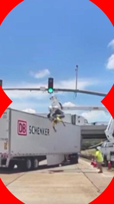 A man in an aerial lift being hit by a lorry. He is hanging upside down.