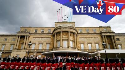 beefeaters stand on ceremony outside buckingham palace as red arrows fly over the palace