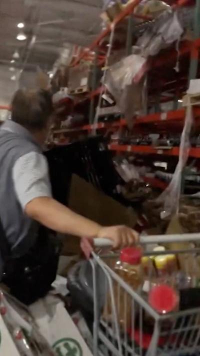 Person holding on to trolley as pallets with merchandise are on the floor