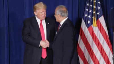 Ambassador Zalmay Khalilzad welcoming Donald Trump to stage