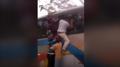 Video shows bus passengers climbing out of the windows, after the vehicle was stranded in floods.