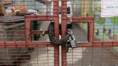 Close up of padlock on closed gate at Kids Company building in Camberwell, London