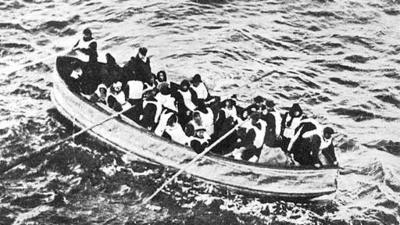 Black and white image of survivors from the Titanic in lifejackets on the lifeboat.  There appears around 20 people onboard.