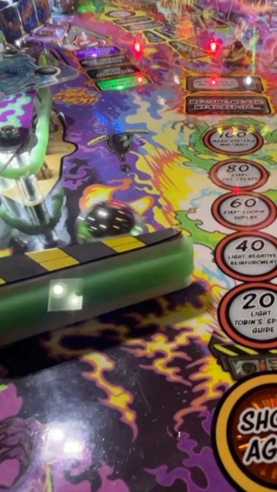 Close up of a pinball machine showing the ball rolling in the game