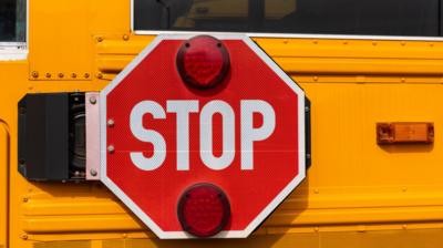 A red stop sign on a yellow school bus