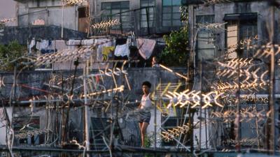 A young resident stands atop one of the Walled City's many rooftops