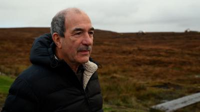 Coinneach Macillinnein, Cathraiche Urras Oighreachd Chàrlabhaigh agus e na sheasachd air a' mhòinteach. 