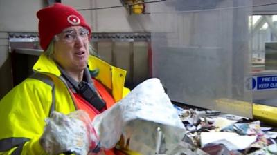 Catherine Crosthwaite removes non-recyclable items from a conveyor belt