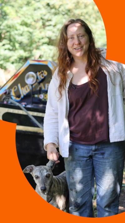 A woman and a dog stand in front of a narrowboat 