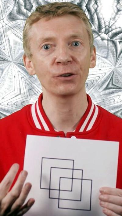Presenter James Grime holding up a puzzle with three squares on it
