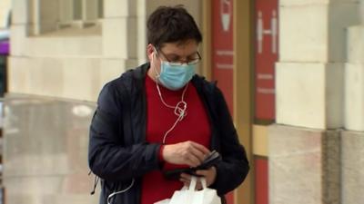 Person wearing a surgical style face mask in the street