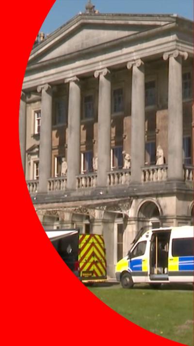 A stately manor with police vans in front