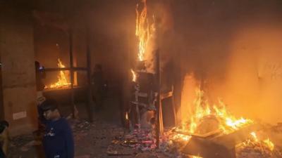 Flames lick the furniture inside a room of former Bangladesh PM Sheikh Hasina's house