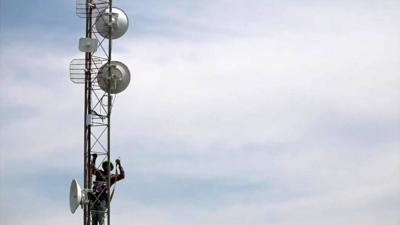 man climbs up network tower