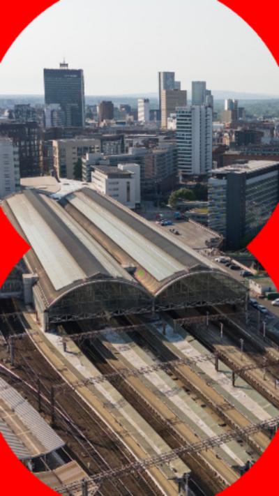 Aerial shot of Manchester Piccadilly train station with the city skyline in the background.